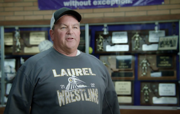 Lineman Lumpy Mark Cloud stands in front of the trophy case at Laurel High School